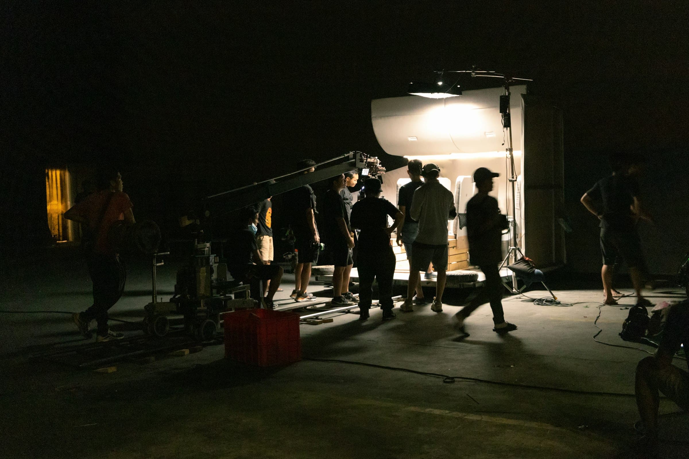 Filmcrew beim Nachtdreh neben Technik-LKW und Setlicht