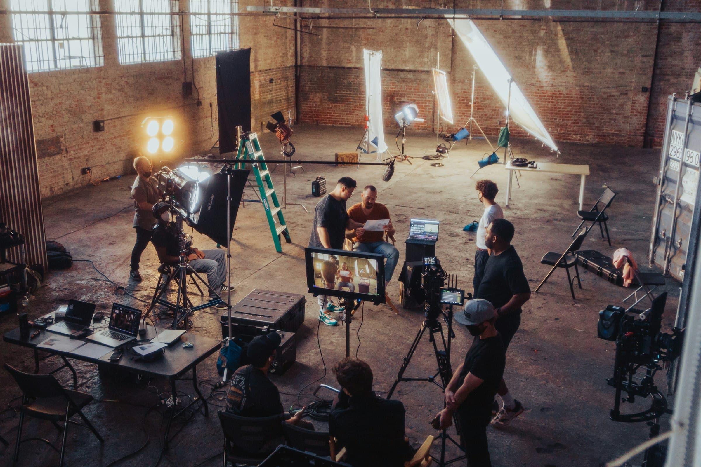 Eingerichtetes Filmset in einer Halle mit Licht, Kamera und Crew
