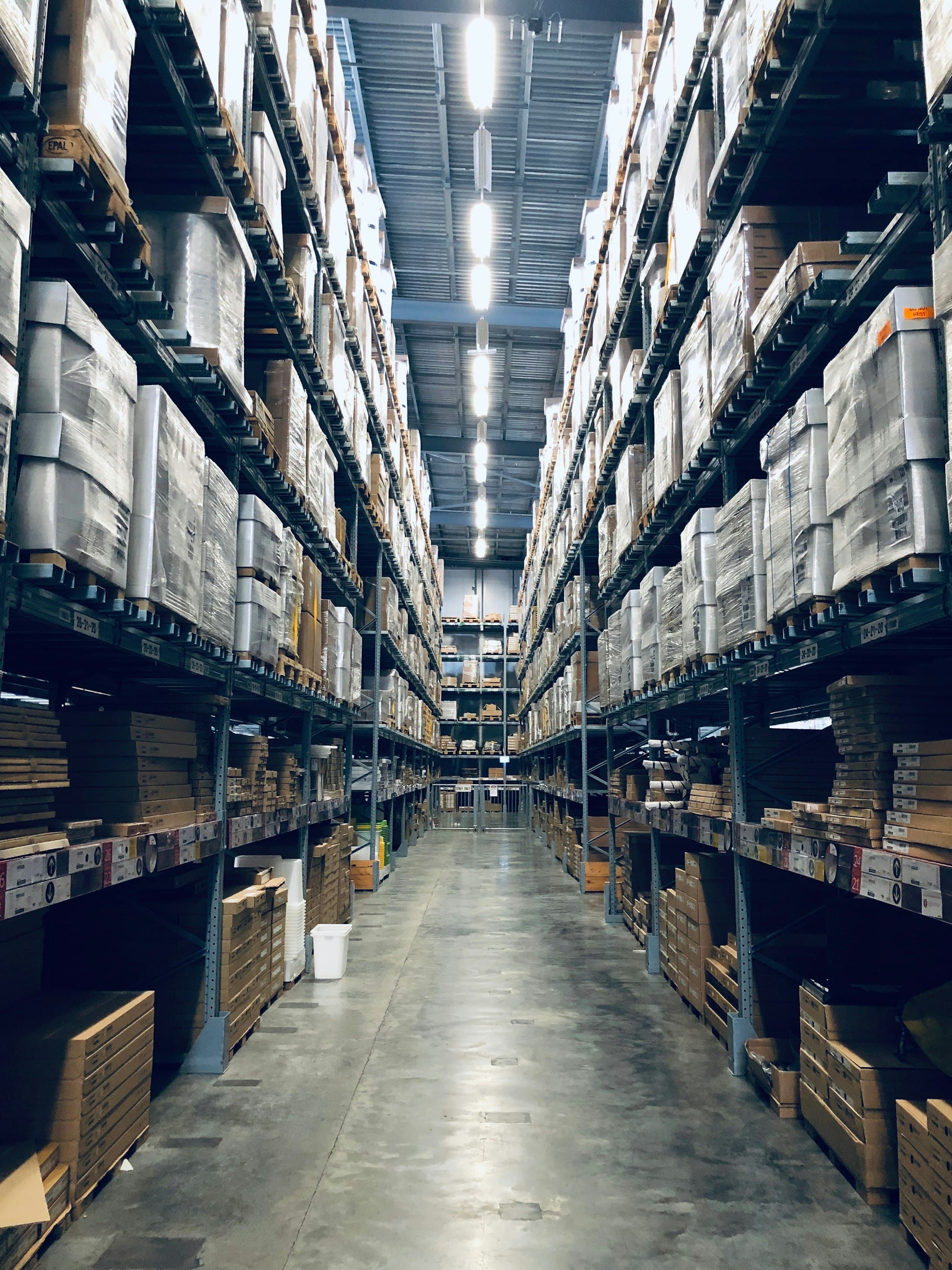 Lagerhalle mit hohen Regalreihen für Produktionsequipment